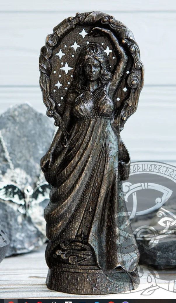 Dark colored handcrafted Nyx statue, showcasing the goddess with stars cut through the wood to shine against the dark background.