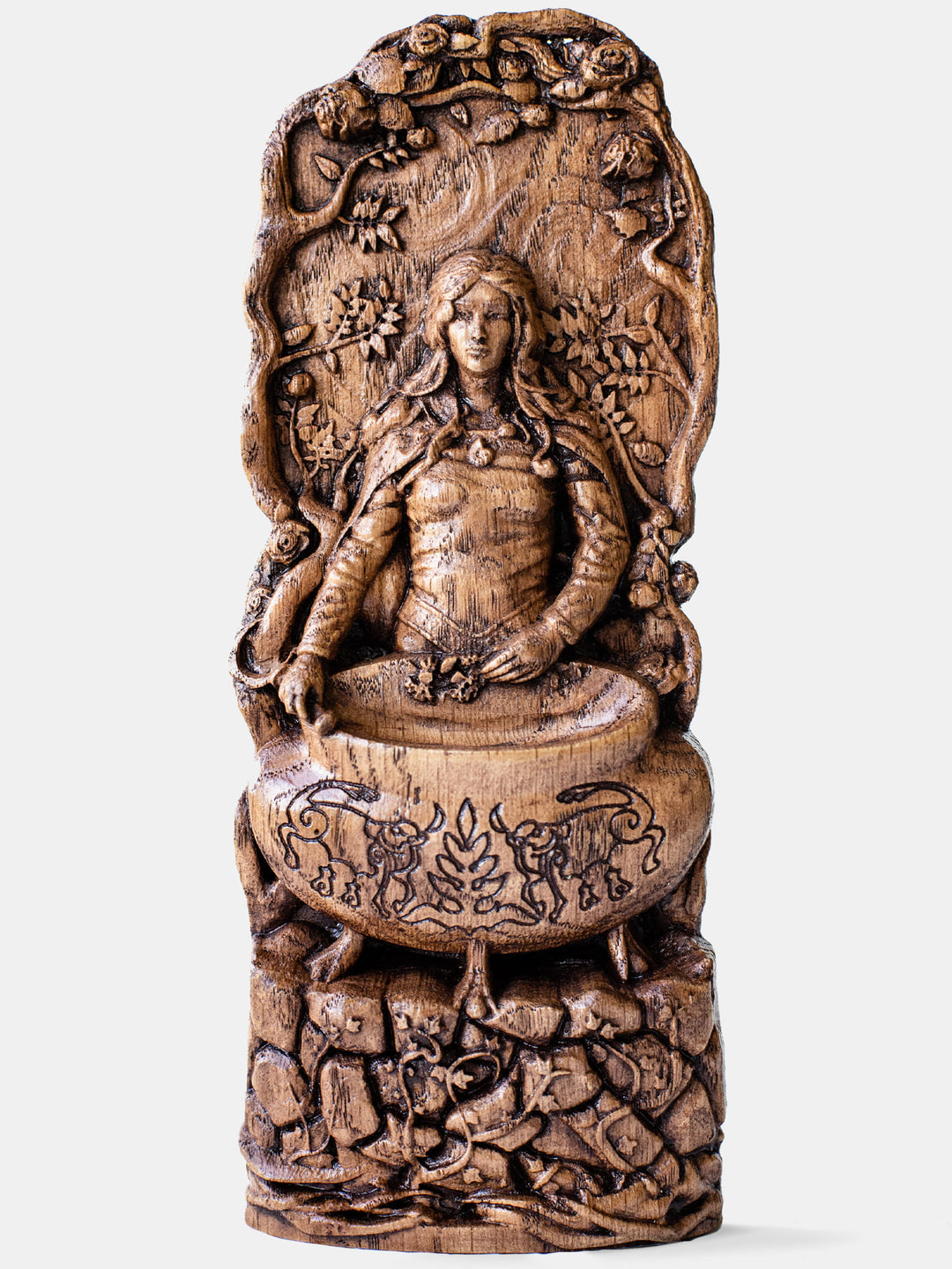 Close-up of the handcrafted oak Ceridwen statue, showcasing detailed carvings of a cauldron and spiral symbol.
