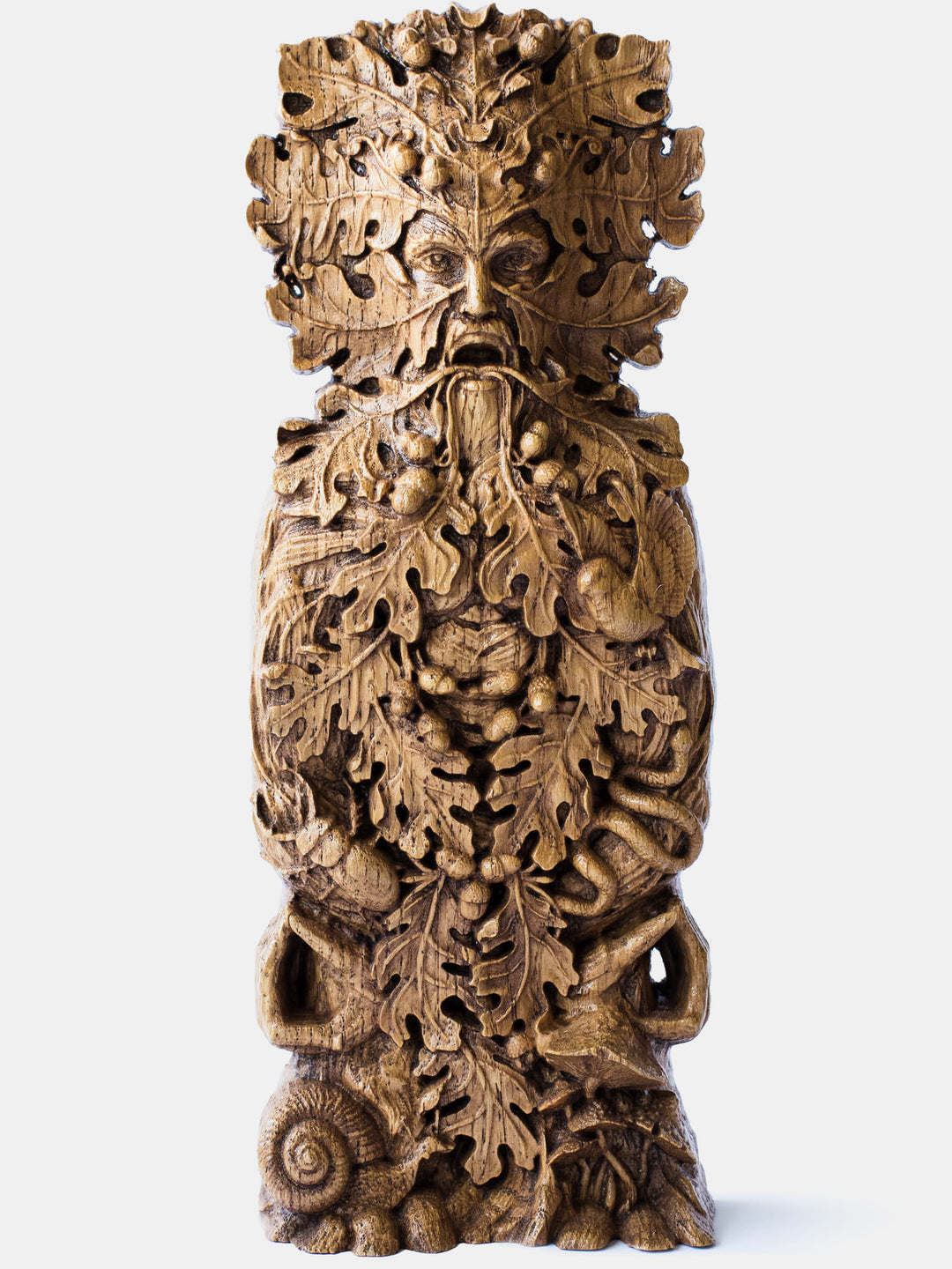 Close-up of the handcrafted oak Green Man bust, showcasing detailed carvings of oak leaves, acorns, and open eyes.