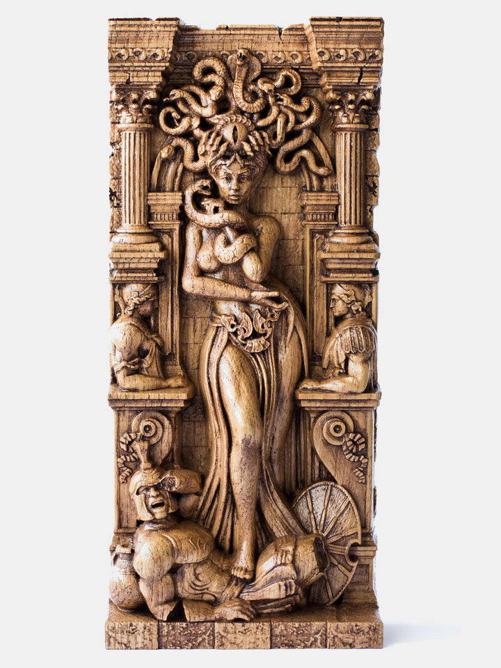 Close-up of the handcrafted oak Medusa statue, showcasing the gorgon standing with one leg on a petrified warrior.