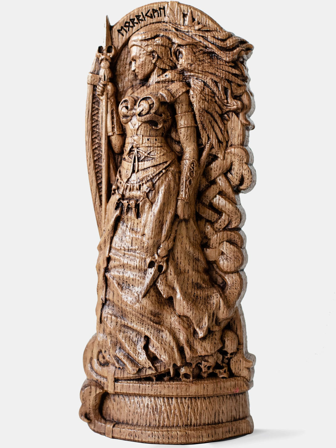 Close-up of the handcrafted oak Morrigan statue, showcasing the goddess holding two spears with ravens emerging from her hair.