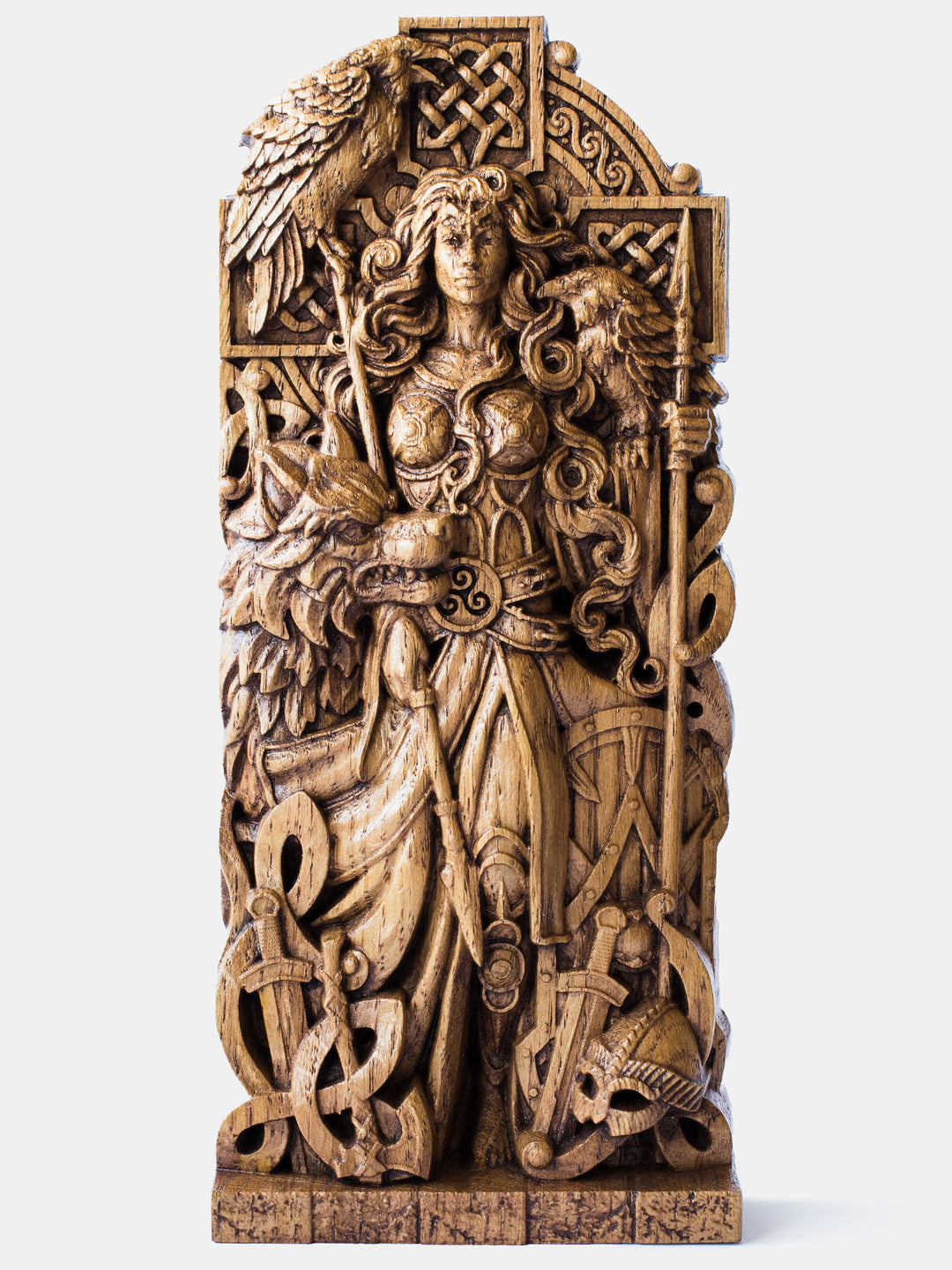Close-up of the handcrafted oak Morrigan statue, showcasing the goddess holding two spears with a Celtic cross in the background, accompanied by two ravens and a wolf.