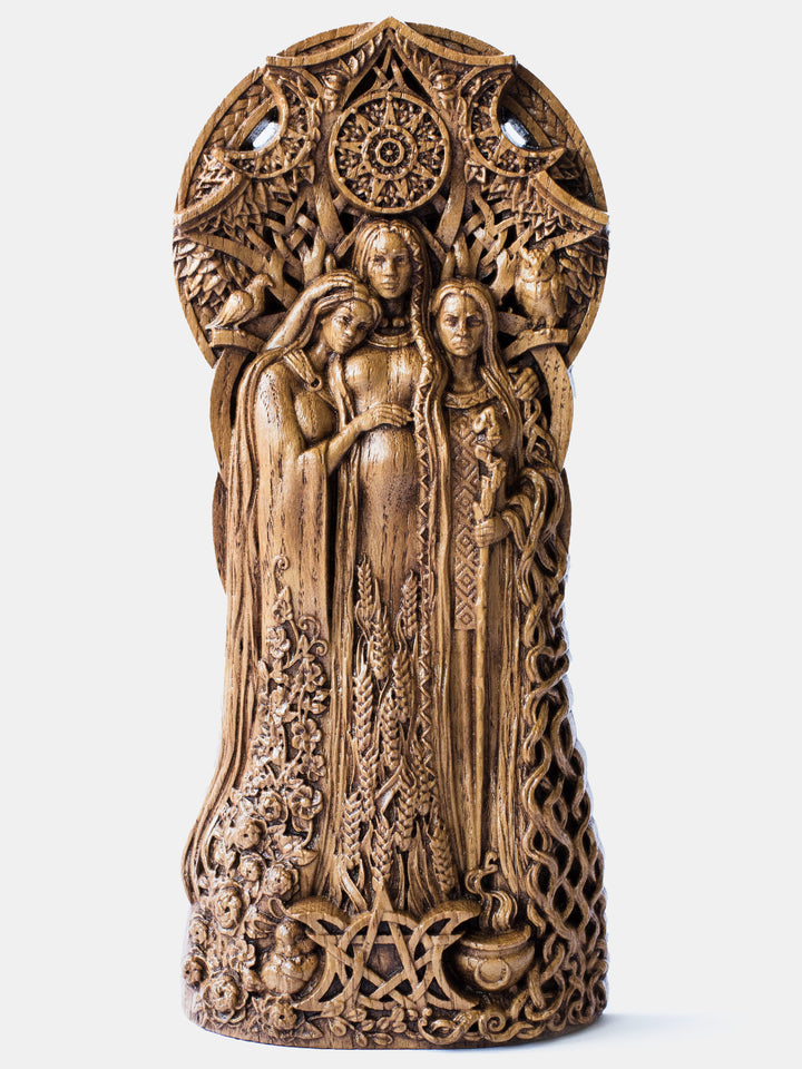Close-up of the handcrafted oak Triple Goddess statue, showcasing the goddess against the backdrop of a triple moon and a tree in phases of flowering, fruiting, and withering.