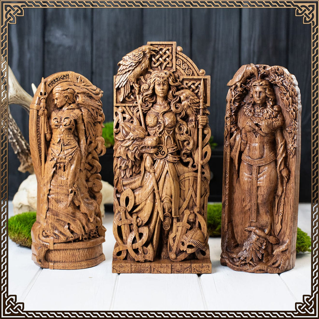 morrigan goddess statue flanked by two detailed wooden figurines representing morrigan celtic goddess and morrigan irish goddess with crow and spear