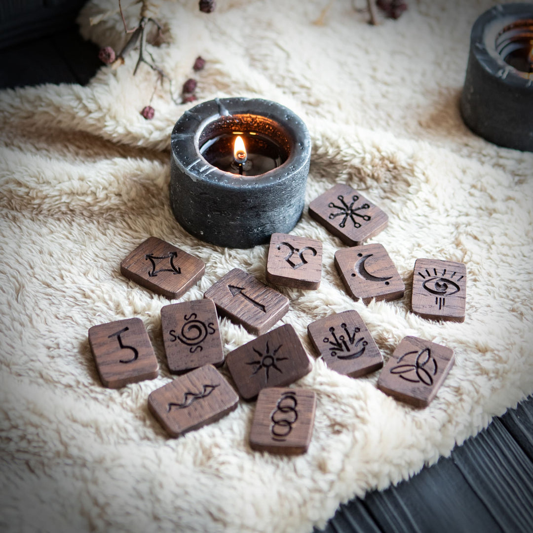 Hand-crafted wooden rune set with witch symbols and candle for pagan divination and altar rituals