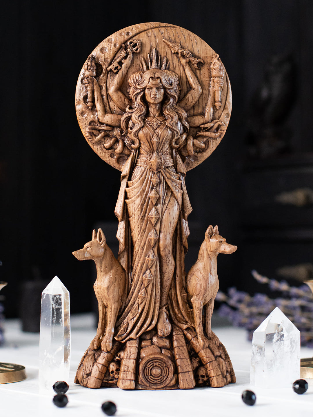 Wooden Hekate figurine with full moon backdrop, sacred tree silhouette and Key of Hecate at her feet