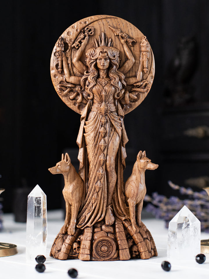 Wooden Hekate figurine with full moon backdrop, sacred tree silhouette and Key of Hecate at her feet