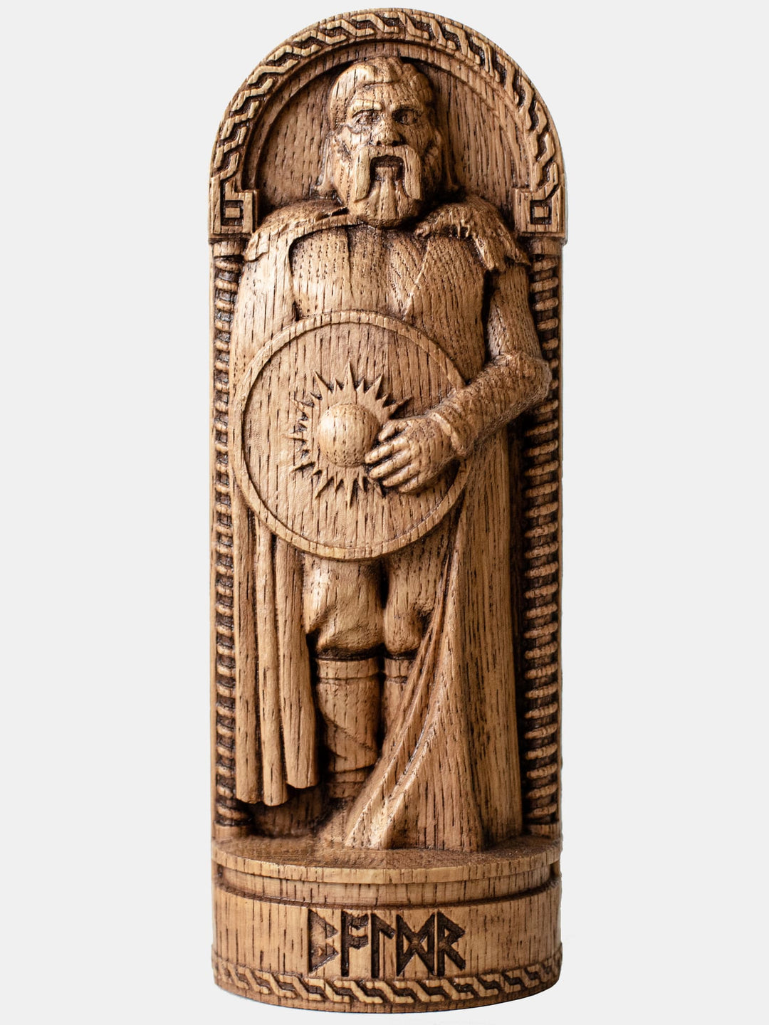 Close-up of the handcrafted oak Baldr statue, showcasing detailed carvings of a shield with the sun.