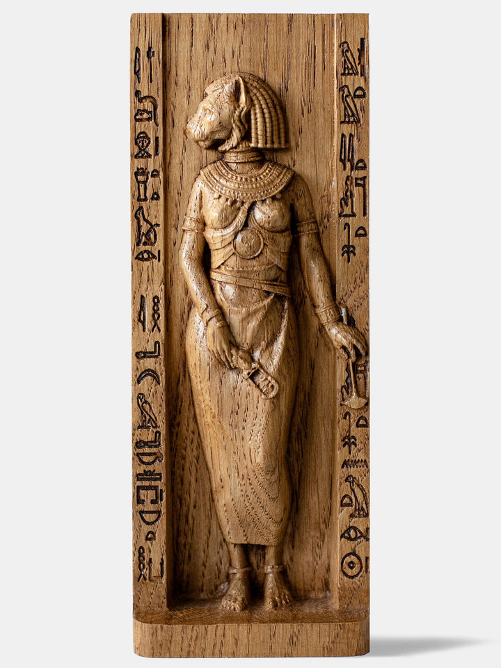 Close-up of the handcrafted oak Bastet statue, showcasing detailed carvings of the ankh and sistrum.