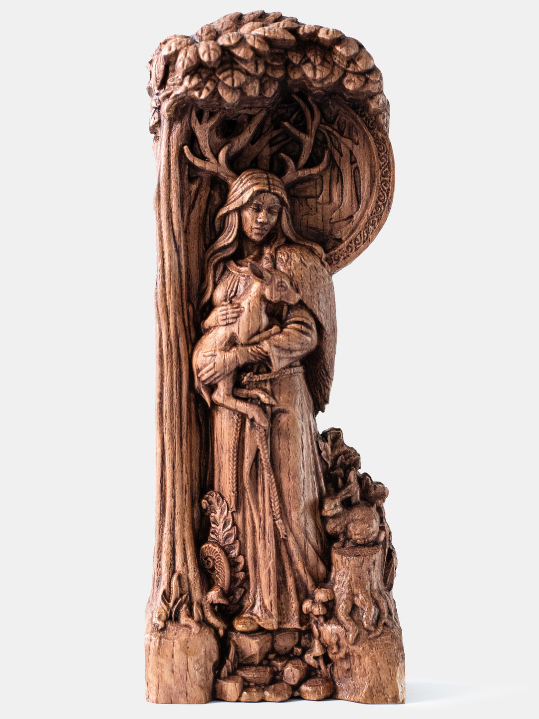 Handcrafted Elen of the Ways horned goddess statue holding a deer on a forest path surrounded by woodland flora