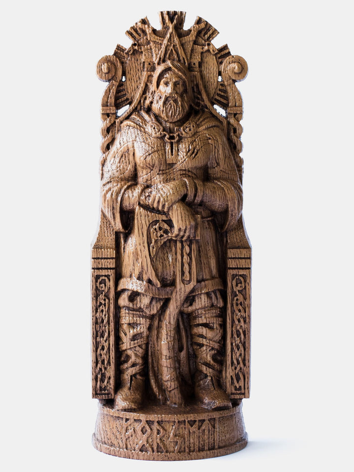 Close-up of the handcrafted oak Forseti statue, showcasing detailed carvings of Forseti holding his ax with the radiant Glitnir Hall in the background.