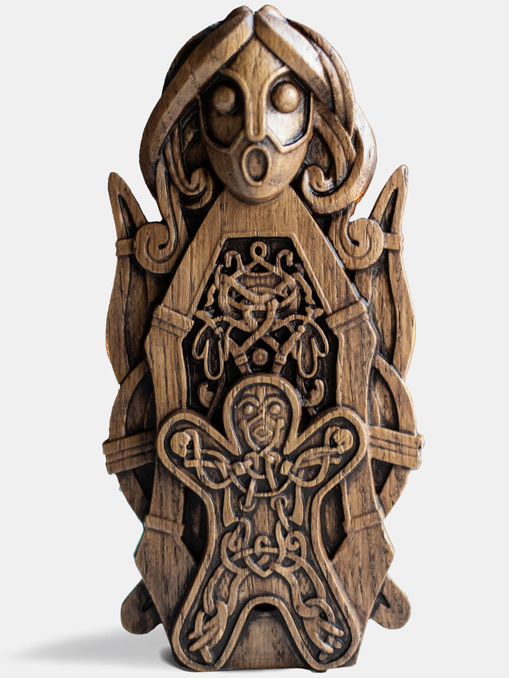 Close-up of the handcrafted oak Frigg statue, showcasing intricate Scandinavian carvings, flanked by a spindle with a child in front.