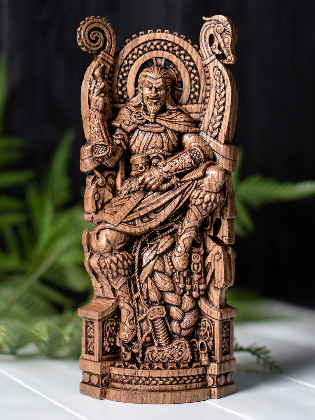 Wooden Loki god statue featuring Jormungandr background, Scandinavian carvings, and trickster-themed symbolic items.