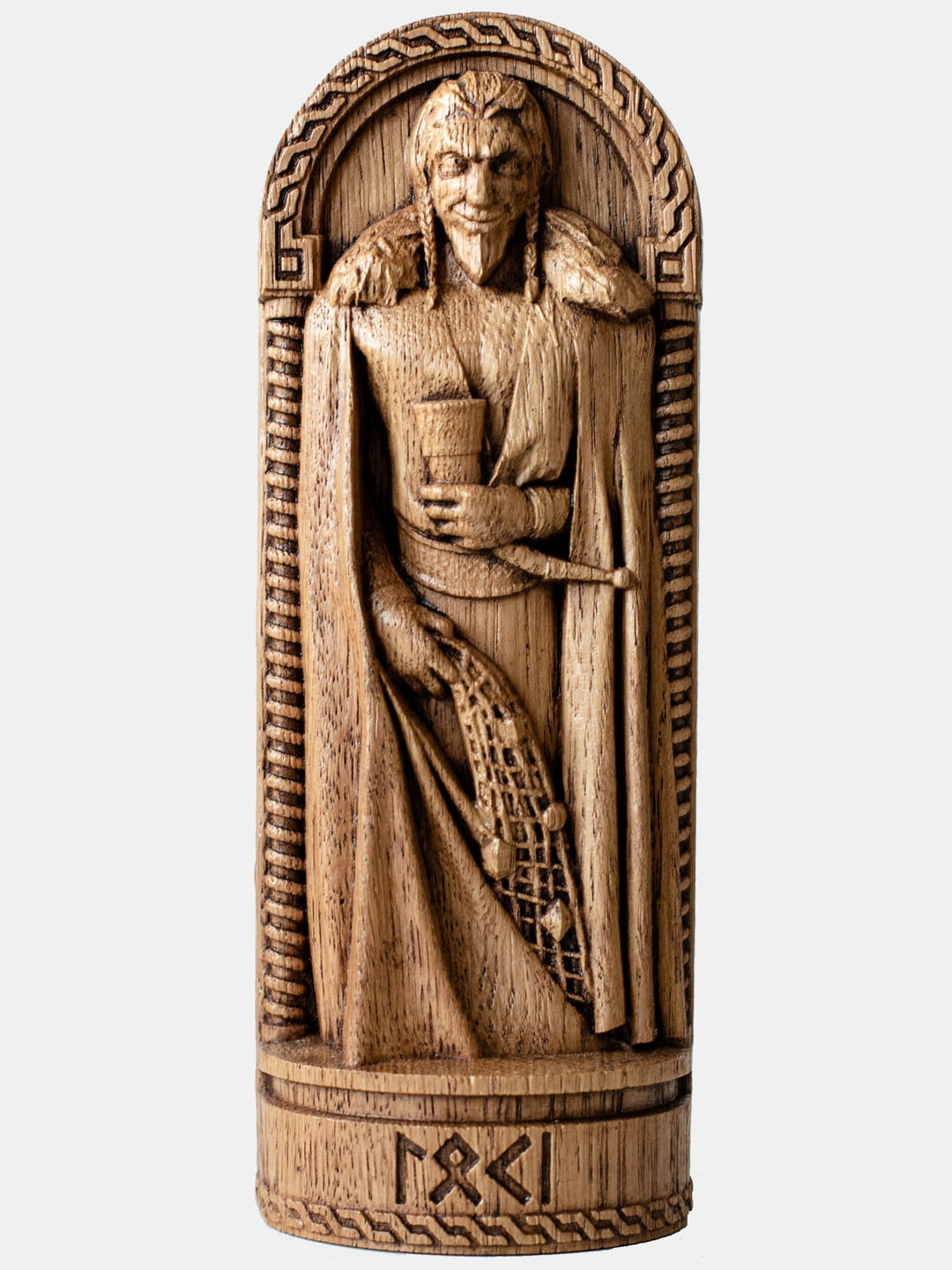 Close-up of the handcrafted oak Loki statue, showcasing the god laughing slyly with a wine horn in one hand and a fishing net in the other.