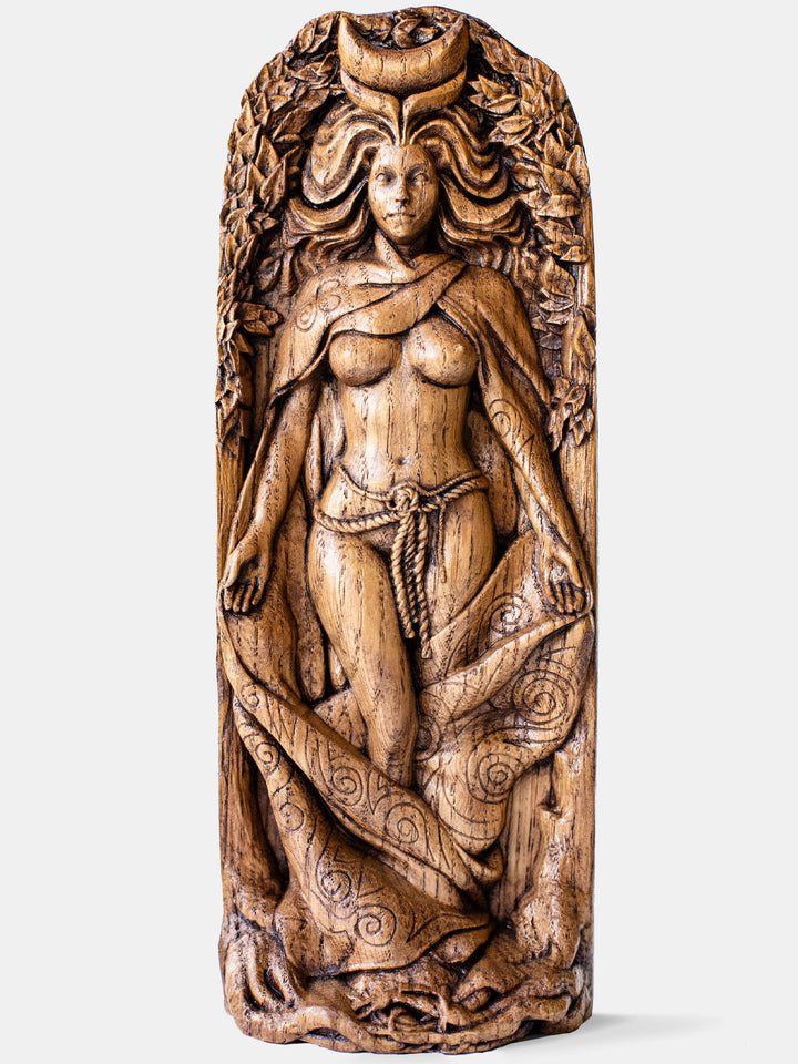 Close-up of the handcrafted oak Moon Goddess statue, showcasing the half-naked goddess standing among trees with the moon on her forehead.