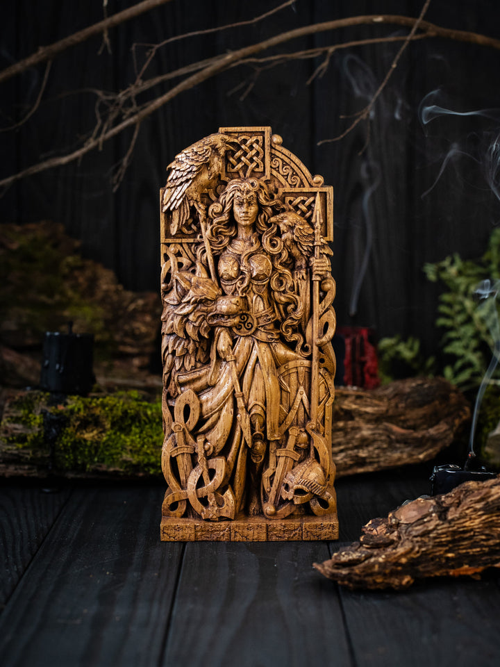 Full view of the Morrigan statue from the front, highlighting its dimensions and intricate design with the weapons of fallen warriors at her feet.