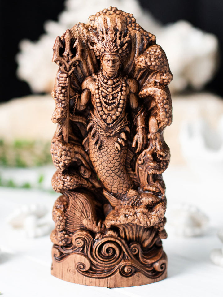 Wooden African deity art figurine of Olokun with fishtail, pearls, shells, and marine creatures among waves.