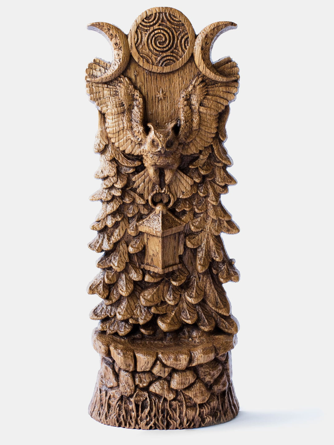 Close-up of the handcrafted oak Owl of Hecate statue, showcasing the owl flying with a lantern in its paws against a triple moon and forest background.