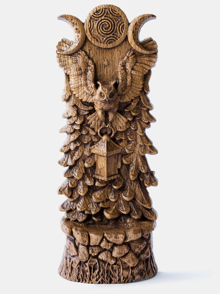 Close-up of the handcrafted oak Owl of Hecate statue, showcasing the owl flying with a lantern in its paws against a triple moon and forest background.