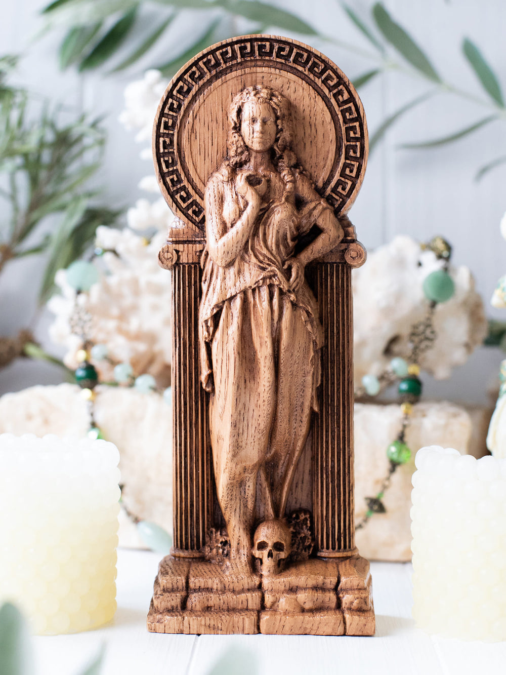 Full view of the Persephone statue from the front, highlighting its dimensions and intricate design with her Greek dress, quatrefoils, and a skull at her feet.