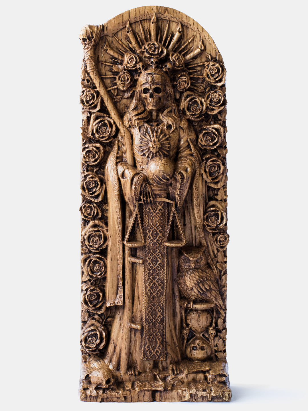 Close-up of the handcrafted oak Santa Muerte statue, showcasing the goddess surrounded by roses, wearing a crown of candles and rays, and holding the planet and scales.
