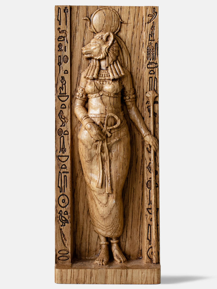 Close-up of the handcrafted oak Sekhmet statue, showcasing the Egyptian Warrior Goddess with a lioness head and solar disk above her head.