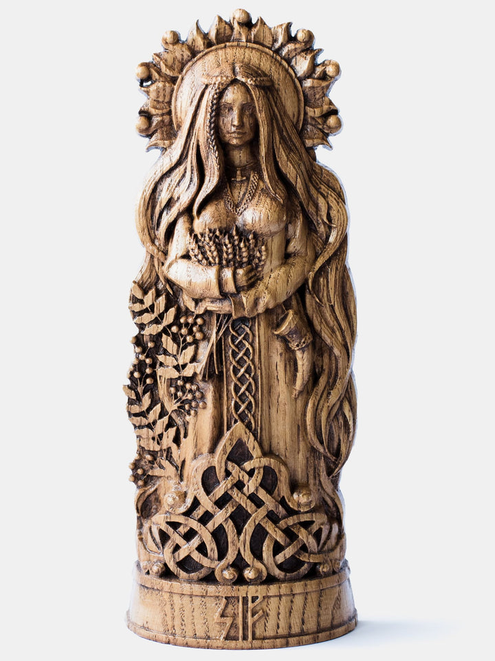 Close-up of the handcrafted oak Sif statue, showcasing the Norse Goddess with flowing hair against the background of the sun, holding ears of wheat.