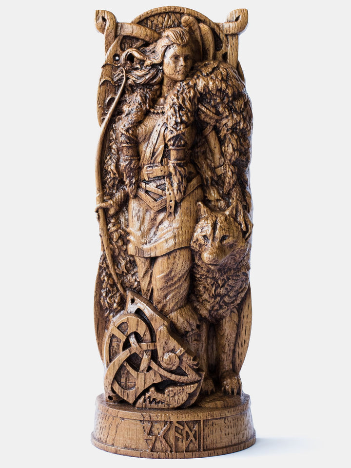 Close-up of the handcrafted oak Skadi statue, showcasing the Norse Giant Goddess in fluffy fur and armor, holding a bow with a wolf beside her.