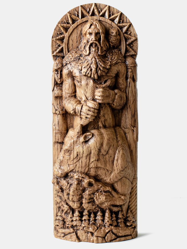 Close-up of the handcrafted oak Veles statue, showcasing the Slavic God of Earth, Waters, and the Underworld with his staff and horn, an owl on his shoulder.