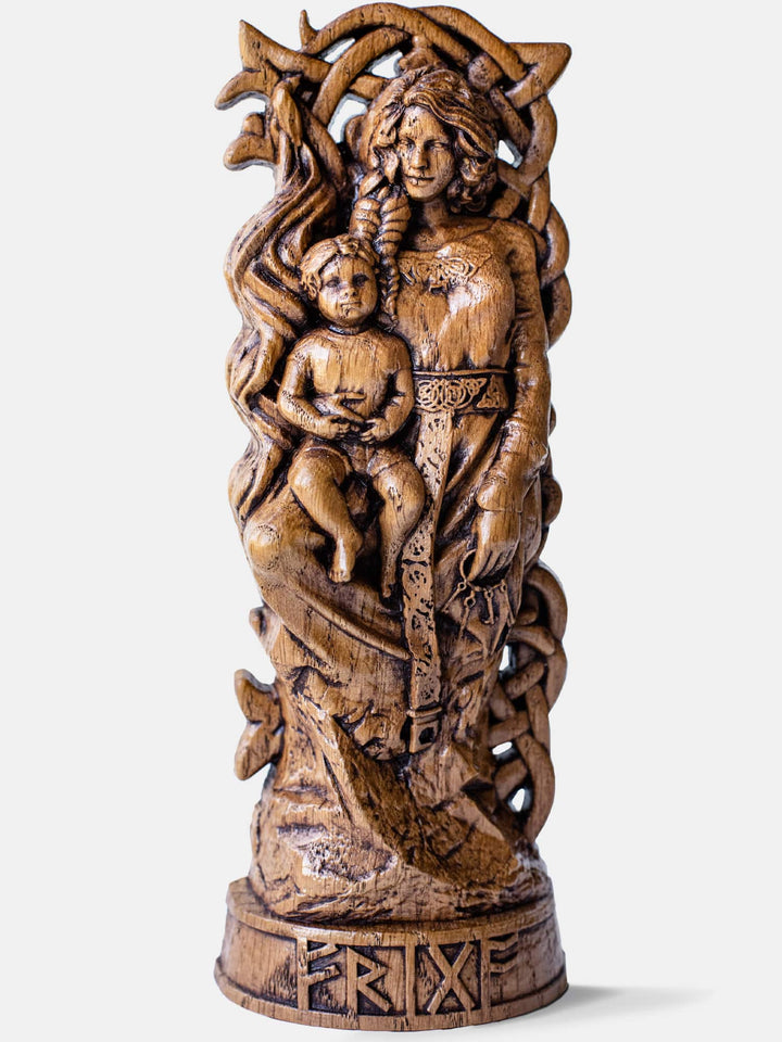 Close-up of the handcrafted oak Frigg statue, showcasing detailed carvings of Frigg with a spindle, keys, and a child in her arms.